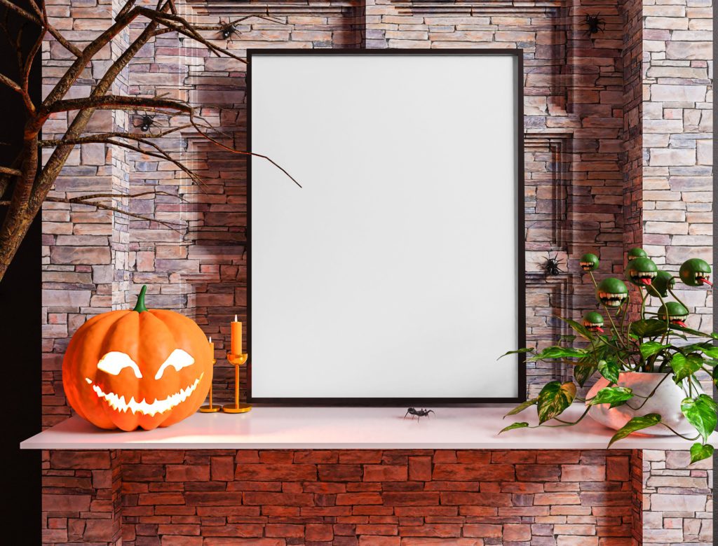 The canvas is on a white table. behind is a stone background. next to the canvas are candles, a pumpkin, spiders and a scary plant.