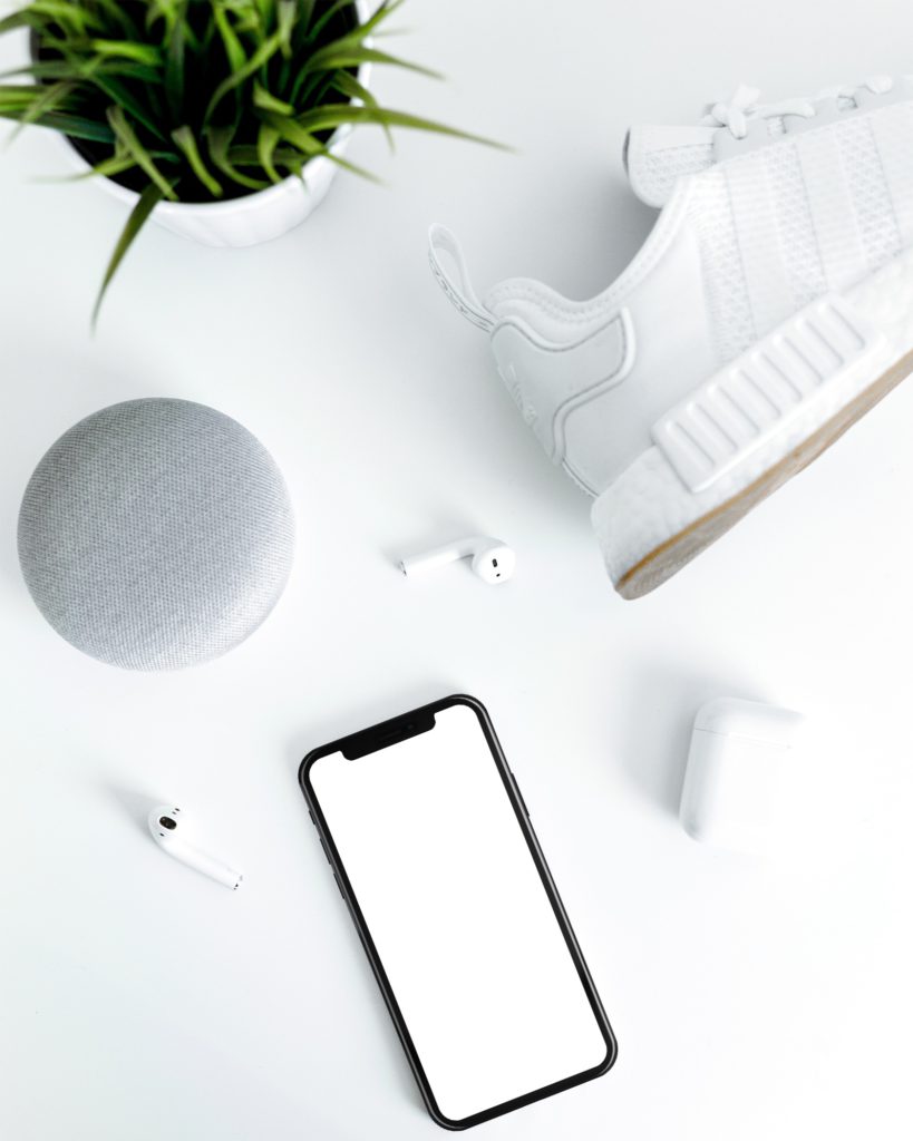 iphone  headphones speaker and plant on white background