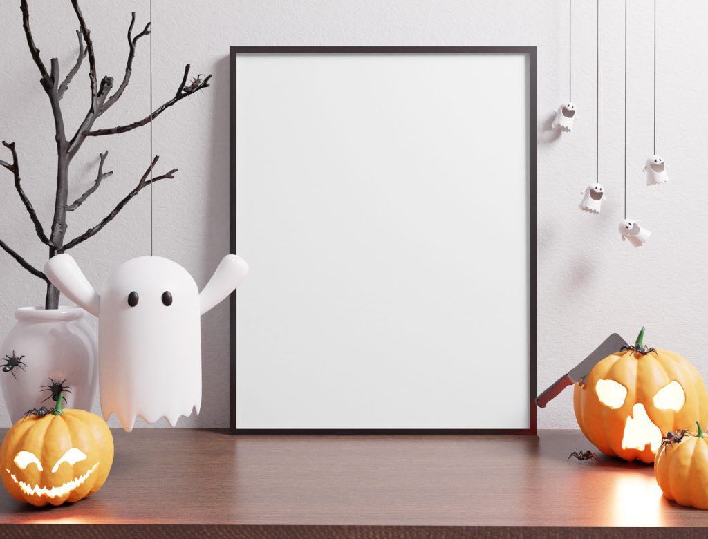 Canvas on a wooden table on a white background. There are pumpkins and ghosts and spiders on the table.